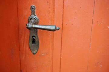 Orange-braune alte Holztür mit altem silbernem Türgriff aus Messing von Haus 