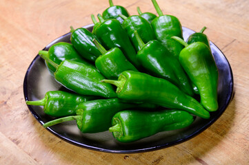 Fresh green mild padron pepper pementos, ready for grill or to be fried with olive oil, traditional snack in Galicia, Spain