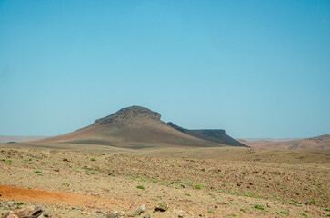 Desert landscapes in Morocco, desolate lands with paths that lead to remote and unexplored corners. Climate change and arid climate. Desertification and lack of water. Mountains and hills