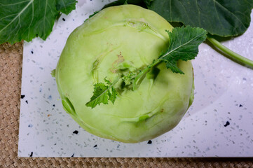 Fresh green kohlrabi with green leaves ready to eat from the garden, new harvest