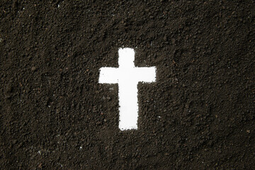 top view of white cross shape with dark soil grim reaper death