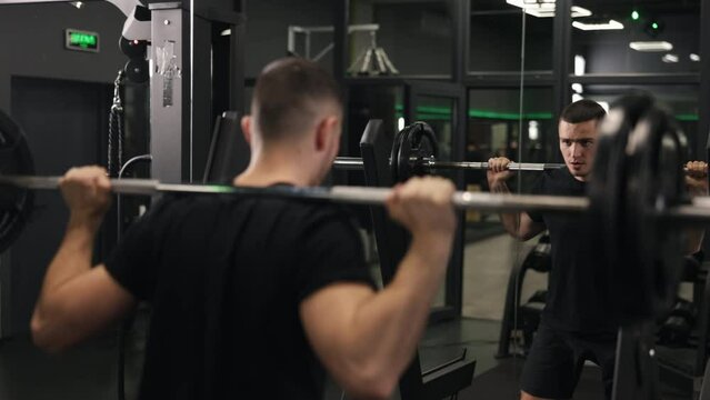 Neck weights, Strength training, Squat progression. Dedicated bodybuilder engages in intensive barbell squat training, showcasing strong masculine energy while promoting healthy way of life