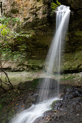 Fototapeta na wymiar Very beautiful waterfall that pours over black stones