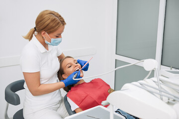 Portrait of a dentist who treats teeth of young woman patient.