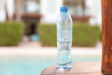 plastic bottles scattered around the pool and beach represent the negative impact of human activity on the environment. The pollution caused by single-use plastic bottles affects the ocean