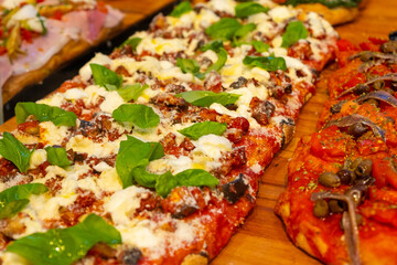 A delicious pizza has a crispy crust, flavorful sauce, melted cheese, and basil on the wooden desk 