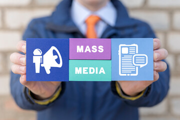 Man holding styrofoam colorful blocks with inscription: MASS MEDIA. Concept of mass media and...