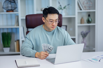 Portrait of concentrated businessman counting money at workplace. Men make easy money.