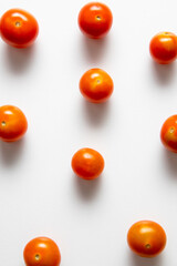 red cherry tomatoes laid on white background