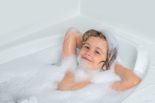 Child bathes in a bath with foam. Washing hair, kids shampoo. Foam on child head.