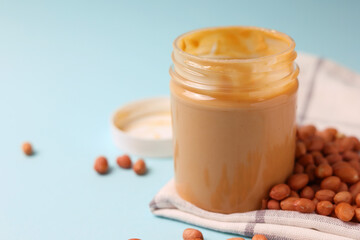 peanut butter and raw peanuts on a colored background