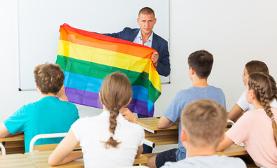 Pupils in classroom listen to the teacher who explains what is LGBT