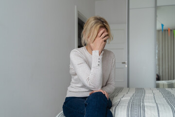 Depressed mature woman at home. Sad face with hands. Mental health problems, gaslighting or bulling...