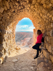 Stone arch in Kerak Castle, crusader castle in Kerak. Woman from behind looks at the panorama.