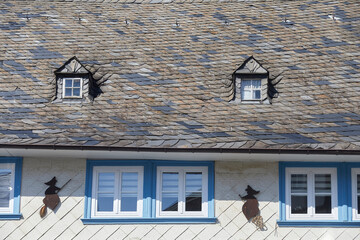 Schöner Fassadenschmuck und Schieferplatten am Dach eines Bürgerhauses in Goslar, Norddeutschland, Niedersachsen.