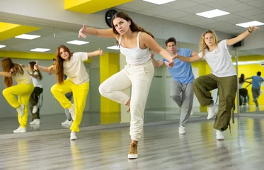 Wall murals Dance School Expressive cool young dancers rehearsing their new dance during training together in studio