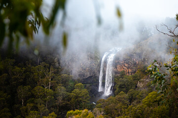 dense clouds and fog above famous ebor falls in new south wales, guy fawkes river national park near dorrigo; unique and spectacular double waterfall in australia, halfway between brisbane and sydney,