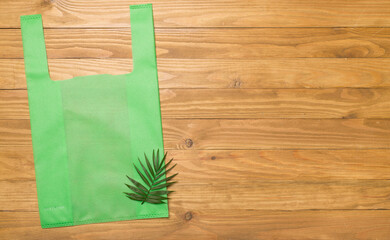 Biodegradable bag on wooden background, top view