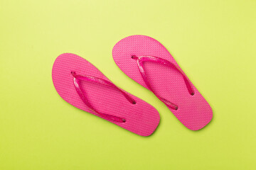 Bright flip flops on color background, top view