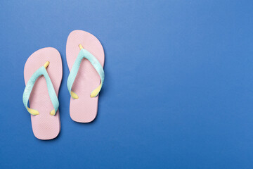 Bright flip flops on color background, top view