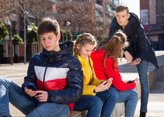 Fototapeta premium Teenagers are playing on smartphone on city street