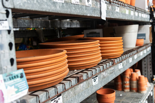 variety of clay flower pots with price tags on the shelves in a garden store.