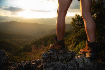 The feet of a traveler resting on a plateau. POV view. Sitting on top of a high hill. Independent concept.