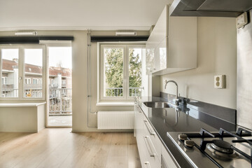 a kitchen with white cabinets and black counter tops in the center of the image is an open window...