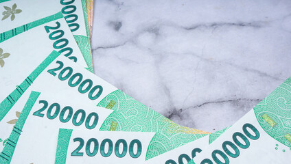 Pile of Indonesian rupiah banknotes series. IDR 20.000 over marble texture background