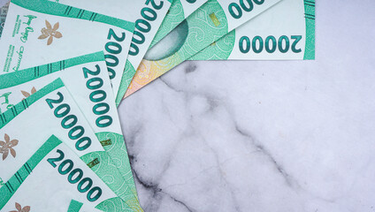 Pile of Indonesian rupiah banknotes series. IDR 20.000 over marble texture background