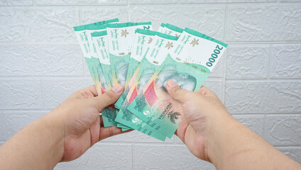 Woman's Hand holding rupiah money