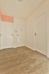 an empty room with wooden floors and white doors on either side of the room, there is no one door