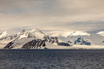 Snow Covered Mountains and Glaciers in The Gullet near Adelaide Island Antarctica Peninsula on a Cloudy Day 