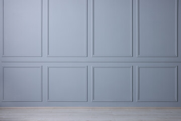 Empty room with light blue wall and wooden floor