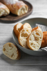 Fresh crispy ciabattas on white wooden table