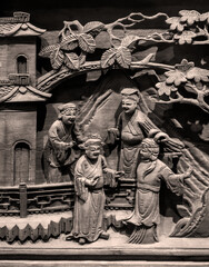 Close-up of wood carving patterns of life scenes on ancient Chinese furniture