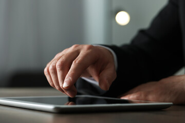 Fototapeta premium Closeup view of man using new tablet at desk indoors