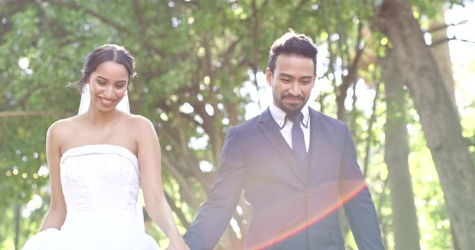 Wedding, park and couple walking and holding hands for marriage ceremony, commitment and celebration. Relationship, partnership and happy bride and groom walk in nature for romance, trust and love