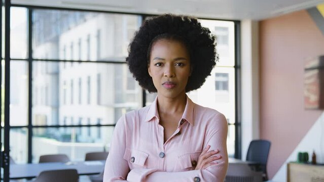 Portrait of serious businesswoman standing in empty modern open plan office looking into camera - shot in slow motion