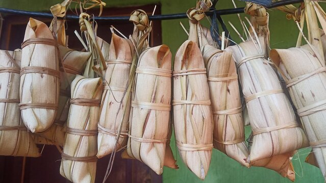 lepet rice cake covered with young coconut leaf and boiled 24 hours on traditional stove hanging in a rope