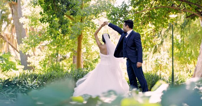Wedding, dance and love with a married couple outdoor in a garden together dancing in tradition after a ceremony. Happy, celebration or relationship with a husband and wife having fun in a park