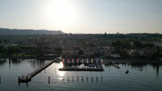 Overview Of Bardolino, Verona City And Cisano Port By The Lake Garda On A Sunny Day In Italy. aerial pull-back