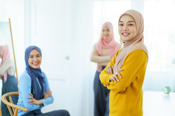 Happy Asian muslim businesswomen having a discussion together in office, modern muslim society and working environment concept. Asian Muslim women friends talking together.