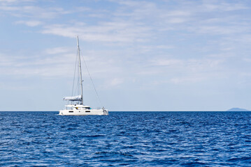 Fototapeta premium Yacht catamaran on the sea. Catamaran sailing on turquoise waters. Holiday or vacation at sea. Luxury yachts. summer
