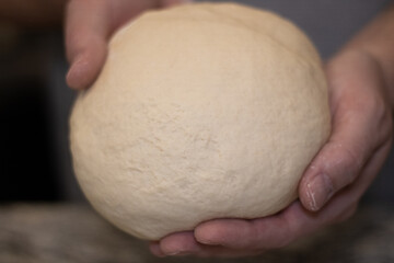 hands holding pizza dough