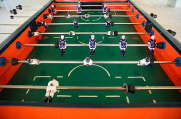 A foosball table is a recreational game symbolizing entertainment, skill, and socializing. It represents teamwork, competition, and the joy of play, and is often associated with bar and culture