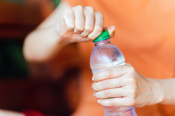 Women holding drinking bottle and opening the cap of a water bottle to drink water.