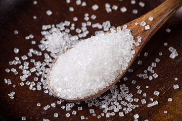 close up of white sugar in wooden spoon