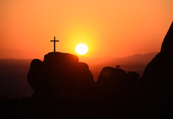 The crucifixion of the crucifixion of jesus christ on the cliffs and mountains. Sunset light. Selective focus.