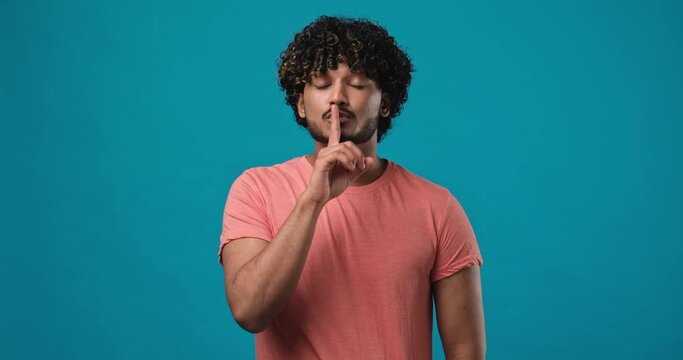 Silence gesture - Portrait of young Indian man closed his mouth with imaginary zipper and throwing the key